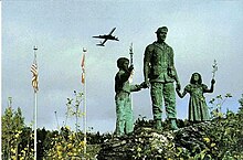 The "Silent Witness" by Kentucky artist Steve Shields. Arrow Air Flight 1285R memorial at Gander Lake, with a DC-8 taking off in the background Gander airport Silent witness.jpg