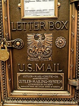 A Cutler letter box showing a door hinge and padlock for the door