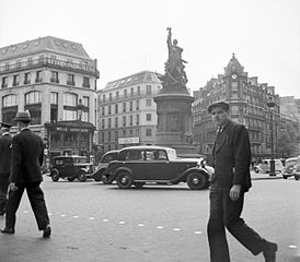 1939年のクリシー広場。左建物は (ボン・マルシェよりも古く)世界初の百貨店, かつ縫製場が設置されたア・ラ・ベル・ジャルディニエール (À la Belle Jardinière)
