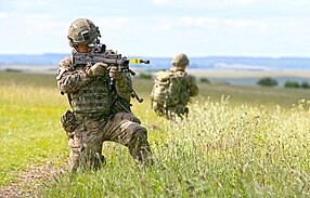 Soldiers equipped with Virtus Scalable Tactical Vest (STV), Virtus Helmet (Batlskin Cobra Plus), and Virtus Load Carriage System, armed with SA80A2s. Pictured are troops wearing the new Virtus body armour and load carrying system in a mock foot patrol scenario MOD 45159192.jpg