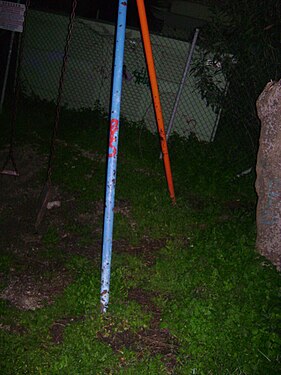 The diagonal supports of a playground swing, night view