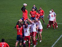Des joueurs de rugby se disputent le ballon après avoir joué une touche.
