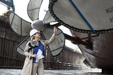 Susan Ford Bales, Gerald R. Ford's sponsor, examines a propeller in Dry Dock No. 12 at Newport News Shipbuilding.