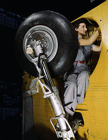 Worker at Vultee-Nashville makes final adjustments in the wheel well of an inner wing before the installation of the landing gear. (February 1942)