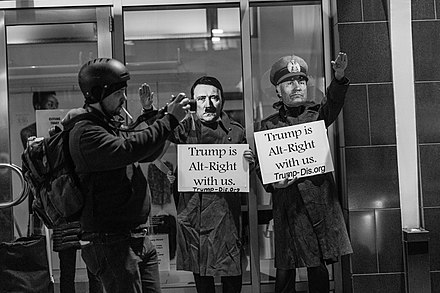 "Trump is Alt-Right with Us". Anti-Trump protesters highlight what they regard as his links to the alt-right and to historical fascism by dressing as Hitler and Mussolini.