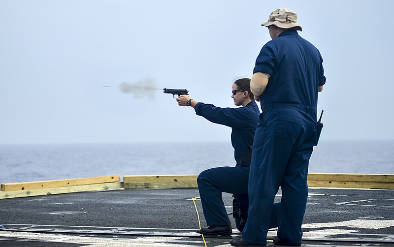 File:U.S. Navy Ensign Cristen Sickal fires an M9 pistol while Chief Master-at-Arms Lawrence Klein supervises during a small-arms qualification aboard the guided missile cruiser USS Monterey (CG 61) in 131105-N-QL471-634.jpg