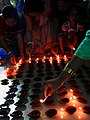 Women lighting earthen lamps on occasion of 2017 Sandhi puja at Manikanchan 18