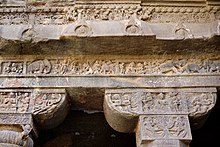 The frieze over the frontage of Cave 1 front shows elephants, horses, bulls, lions, apsaras and meditating monks. 008 Cave 1, In the Forest (34239644366).jpg