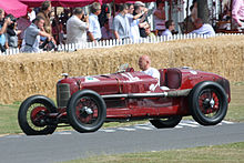 Foto eines roten Alfa Romeo P2, der mit einem Fahrer hinter dem Lenkrad demonstriert wird