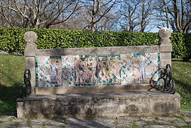 Photographie d'un banc en pierre recouvert de céramiques.