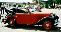 The trio arrive in a red Adler Trumpf Junior similar to the one pictured.[3]