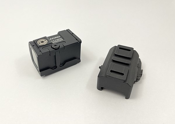 Left: Aimpoint Acro C2 reflex sight laying on its side. Right: Acro rail on a Picatinny riser.