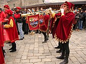 A trumpeter in medieval costume plays a trumpet with a piston. This type of single-valved clarion was specially designed for the performance of the "Triumphal March" of Giuseppe Verdi 's Aida.