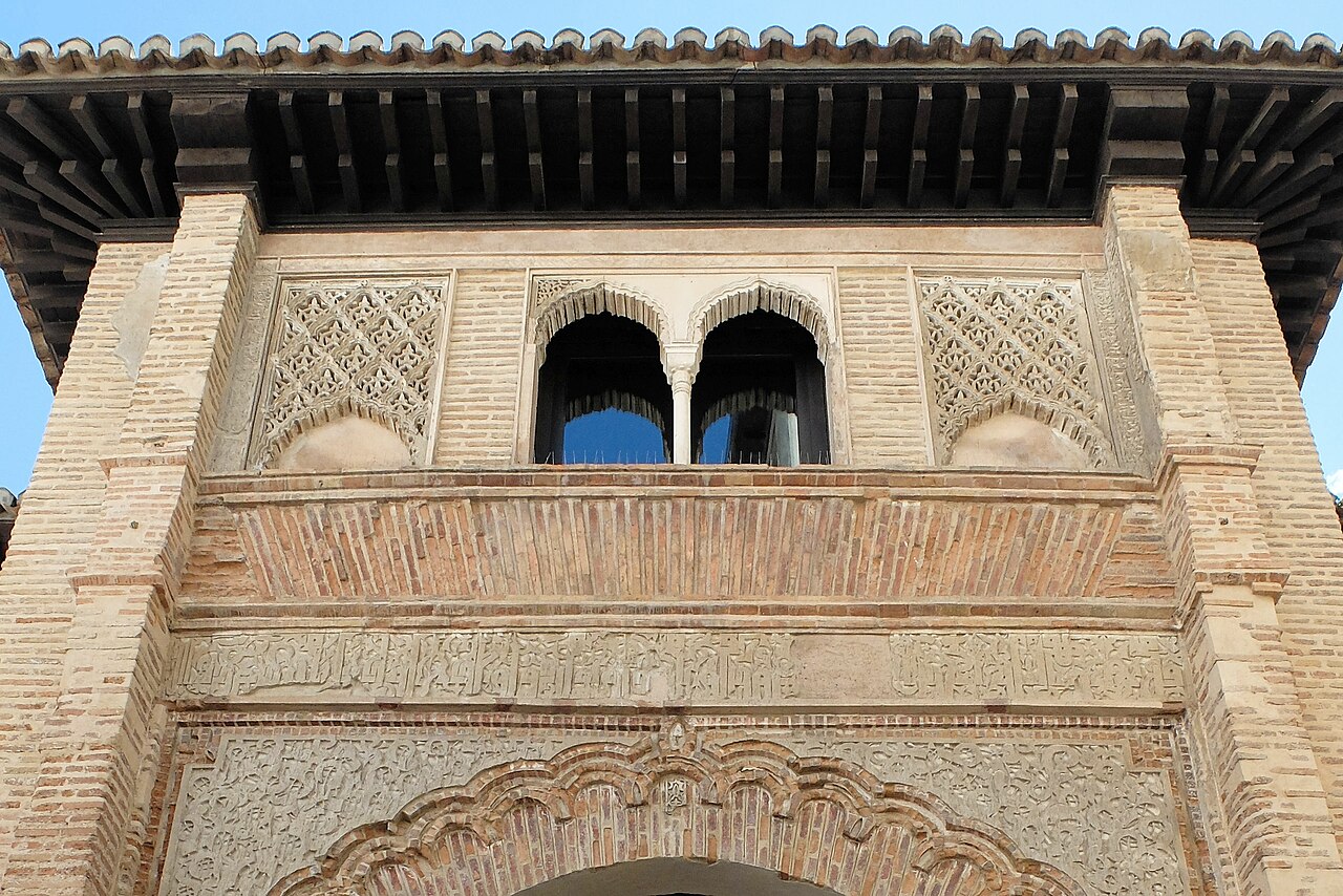 The decoration above the archway of the entrance, including the Kufic inscription