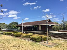 Daglish station platform viewed from Railway Road. The hedges in the foreground spell out DAGLISH. Daglish Station, Western Australia, January 2022 07.jpg