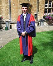 A doctor of philosophy of the University of Oxford, in full academic dress. The typical dress for graduation are gowns and hoods or hats adapted from the daily dress of university staff in the Middle Ages, which was in turn based on the attire worn by medieval clergy. Dphil gown.jpg