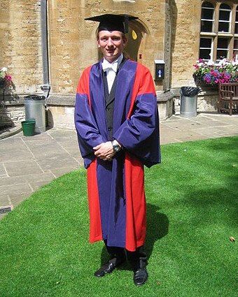 A doctor of philosophy of the University of Oxford, in full academic dress. The typical dress for graduation are gowns and hoods or hats adapted from the daily dress of university staff in the Middle Ages, which was in turn based on the attire worn by medieval clergy.[114]