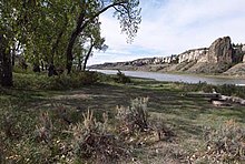 LaBarge Rock (dark pillar against white sandstone, extreme right of photo) as seen from Eagle Creek camping area, site of Lewis and Clark camp on May 31, 1805