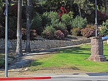 Picture of the entrance to Elysian Park with path, stone wall, and sidewalk