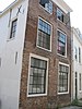 Hoekhuis aan open pleintje halverwege de straat