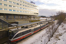 Trondheim Airport Station at the airport terminal is located on the Nordland Line, here with an NSB Class 93 train; in the background is the airport's Radisson Blu hotel.