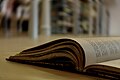 Focus on an open book on a wooden floor in a library