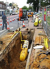 Polyethylene plastic main being placed in a trench Polyethylene gas main.jpg