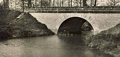 Photographie en noir et blanc d'un pont franchissant une rivière.