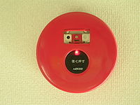 An activated manual call point in Japan. Telephone jacks are visible beneath the open cover. Proprietary-type fire alarm manual call point-activated.JPG