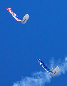 Two parachute jumpers carrying the United States and Alaskan flags.