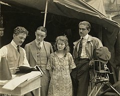 Discussing script on location for Sunshine Alley (1917); from left: director John W. Noble, Harron, actress Mae Marsh, and cameraman George W. Hill