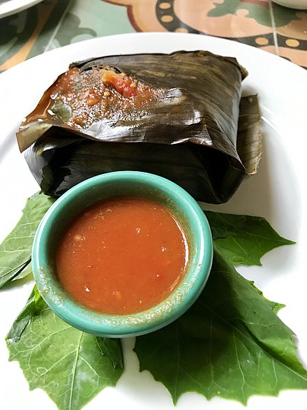 Tamal colado—typical Maya dish, corn dough mixed with turkey and vegetables, wrapped and baked in a plantain leaf