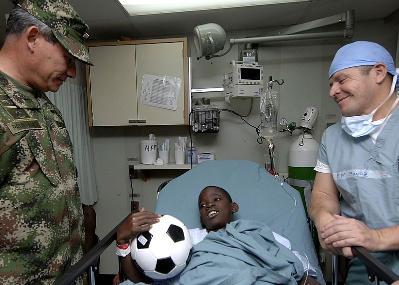 File:US Navy 070827-N-6278K-116 Gen. Fredy Padilla, commander of Colombian military forces talks with Jhonajaro Montano, a recovering patient in the post-operation section of the operating room on board Military Selift Command hospi.jpg