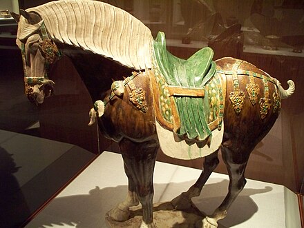 A sancai lead-glazed earthenware horse statue with a saddle, Tang dynasty (618–907 AD)