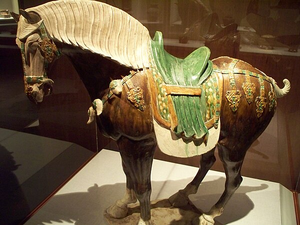 A sancai lead-glazed earthenware saddled horse statuette, Tang dynasty (618–907 AD), coloured lead glazes.