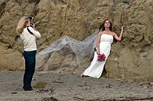 A modern-day wedding photographer shooting on a beach Wedding photographer preparing shot.jpg