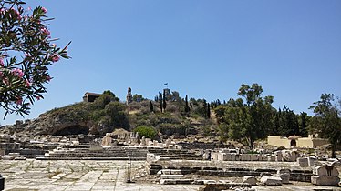 Cour dallée à l'entrée du sanctuaire. Le temple d'Artémis est au premier plan, à droite.