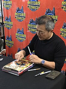 Artist Jim Lee signing a hardcover collected edition of his work on X-Men (Vol 2) at Midtown Comics in Manhattan 12.5.19JimLeeXMenV2HCByLuigiNovi2.jpg