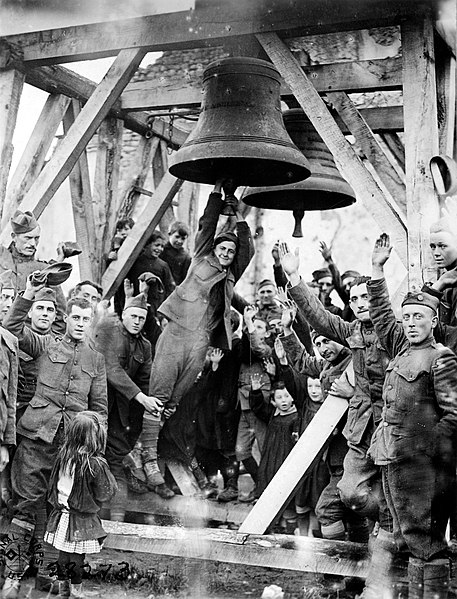 Private J. R. Fletcher, 80th Division, and children of Vaubecourt ring church bells that had been blown from the belfry by Germans forces in 1914 on t