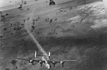 A USAAF B-24 bomber emerges from a cloud of flak with its no. 2 engine smoking. B-24 Flak.jpg