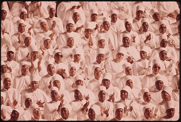 Women members of the NOI at a Saviour's Day meeting in 1974. A women's outfit incorporating a headpiece and full-length garment covering the arms and 