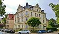 Apartment building in open development in a corner with an enclosure and front garden