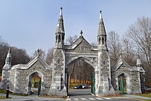 Archway with three gates and four spires, constructed of stone and bricks