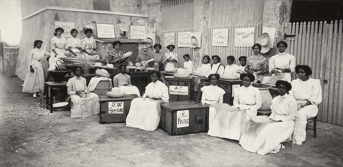 Pupils in a school for hat weaving, Pietermaaistraat, Willemstad. At the back, there's H.J. Cohen Henriquez, president of the 'Curacaosche Vereening van Hoedenvlechtsters Arbeid Adelt'. Photo by Soublette et fils, between 1915 and 1920. Collection Nationaal Museum van Wereldculturen.