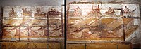 A wall in the dressing room in the suburban baths. On this wall there are seven paintings of sexual scenes located above paintings of numbered boxes on a shelf. An eigth painting is of a nude male. 62 to 79 CE Composite image - Scenes I to VIII in Room 7 of the Suburban Baths - Pompeii.jpg - 2nd Version.jpg