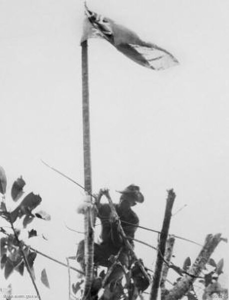 Tom Derrick raising the Australian flag over Sattelberg mission