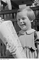 Fotothek df roe-neg 0006707 024 Ein lachendes Mädchen mit Schulranzen und Zuckertüte vor einem Gartenzaun.jpg
