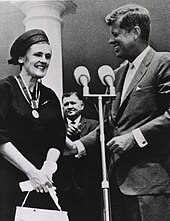 Black-and-white photo of a smiling Kelsey meeting with President John F. Kennedy; the medal for the President's Award for Distinguished Federal Civilian Service hangs around Kelsey's neck