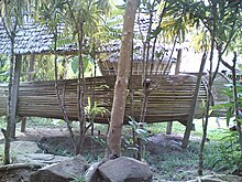 A large ceremonial bumbu ikan (fish trap) in a Rungus village in Kudat, Sabah in Borneo. A longhouse can be seen in the background, with distinct outward-sloped walls. GiantRungusBumbuIkan.jpg