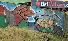 Mural in Belfast depicting a Glentoran fan with flat cap, scarf and rattle. Glentoran mural, Belfast - geograph.org.uk - 3886978.jpg